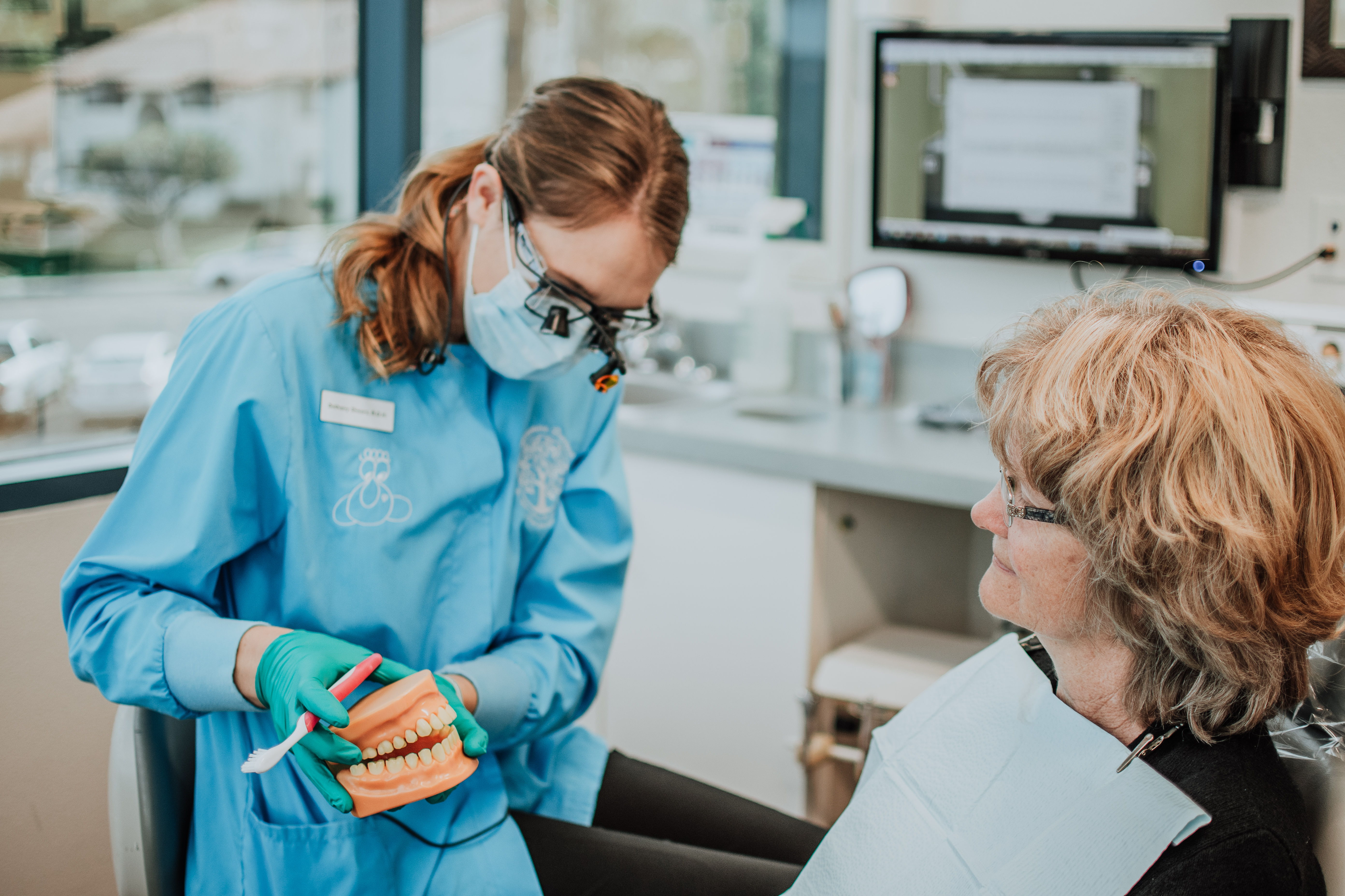 Hygenist showing patient toothbrushing techniques